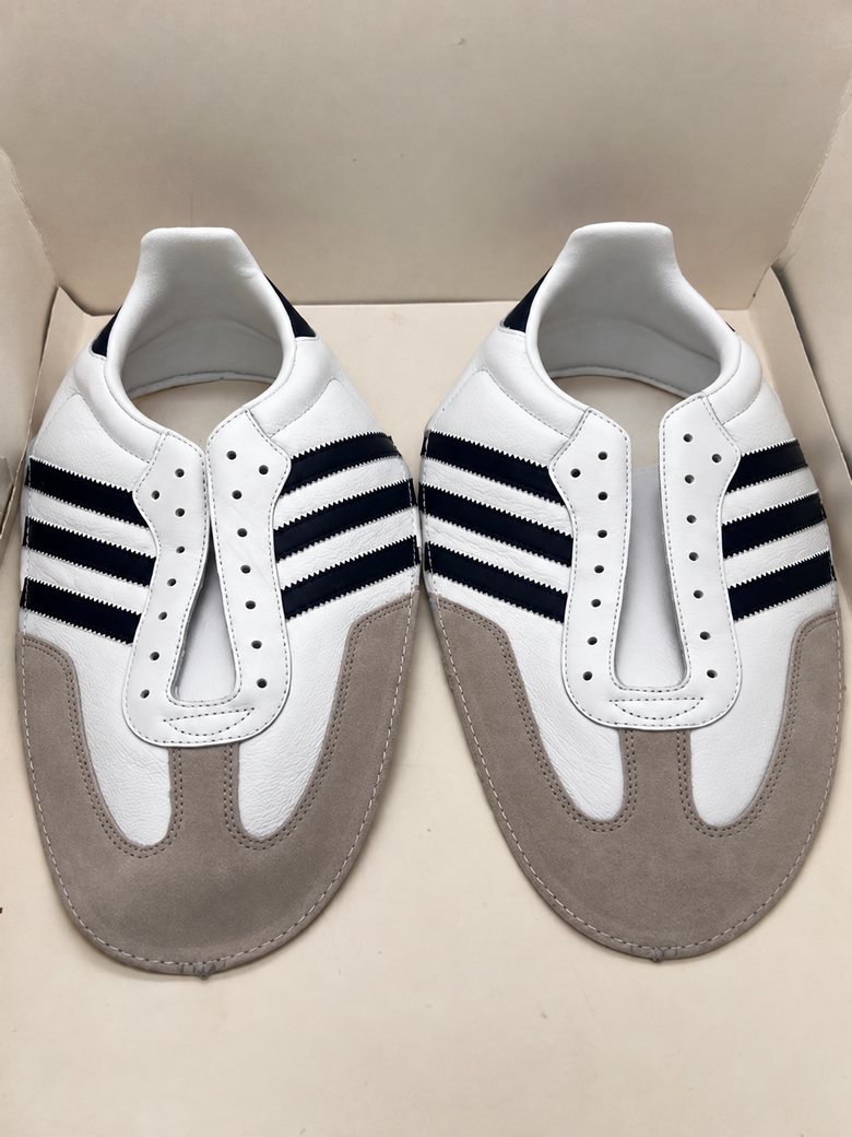 White leather upper with black stripes and grey suede overlays