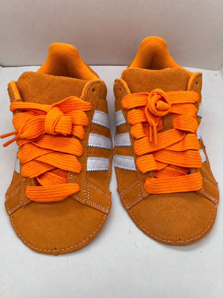 Orange suede upper with white stripes and orange laces